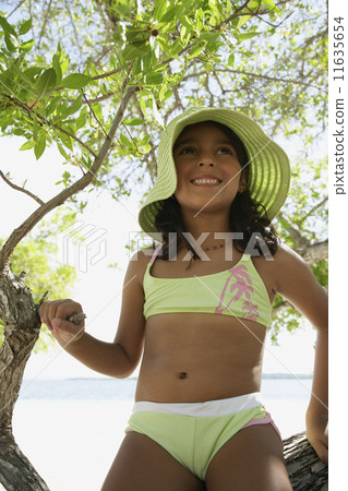 Hispanic girl in bathing suit under tree 11635654