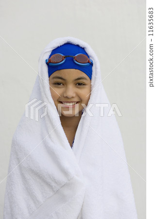Hispanic girl in towel with swimming cap and goggles Hispanic girl in towel with swimming cap and goggles 11635683