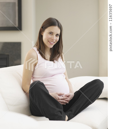 Pregnant woman sitting on sofa Pregnant woman sitting on sofa 11635697
