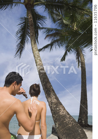 Asian man applying sunscreen to girlfriend 11635706