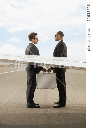 Multi-ethnic businessmen exchanging briefcase 11635728