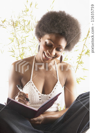 Woman writing in journal Woman writing in journal 11635759