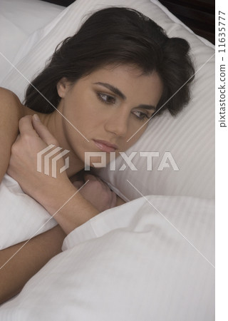 Hispanic woman laying in bed 11635777