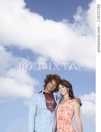 Multi-ethnic couple hugging outdoors 11635788
