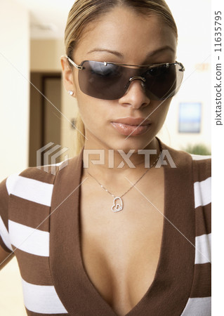 Hispanic woman wearing sunglasses 11635795