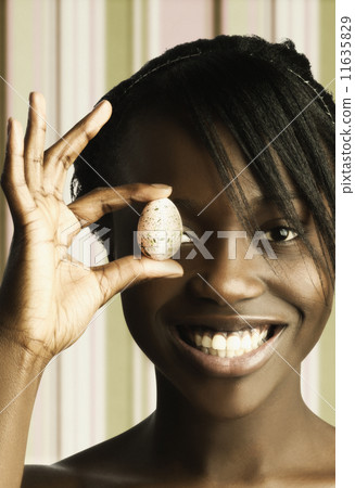 Headshot of woman holding egg Headshot of woman holding egg 11635829