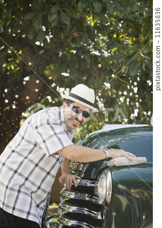 Hispanic man waxing truck 11635836