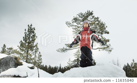Boy standing in snow with arms outstretched Boy standing in snow with arms outstretched 11635840