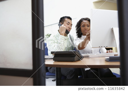 Two businesspeople working at desk 11635842