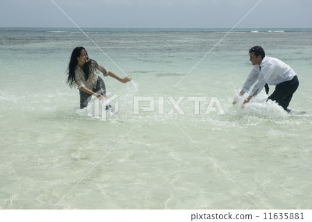 Hispanic businesspeople playing in water Hispanic businesspeople playing in water 11635881