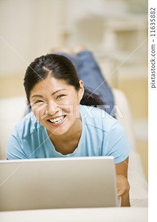 Asian woman on sofa with laptop Asian woman on sofa with laptop 11635882