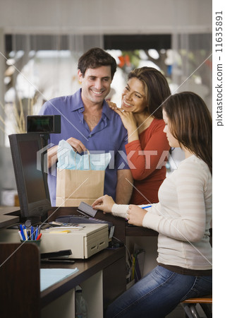 Hispanic couple shopping in clothing store Hispanic couple shopping in clothing store 11635891