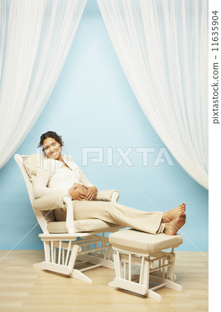 Pregnant Mixed Race woman sitting in rocking chair Pregnant Mixed Race woman sitting in rocking chair 11635904
