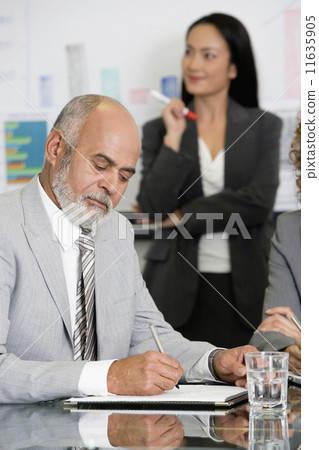 Senior African businessman writing at table Senior African businessman writing at table 11635905