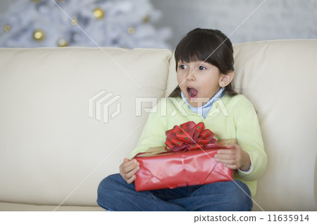 Hispanic girl holding Christmas gift 11635914