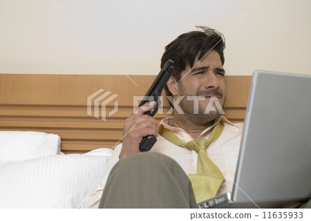 Hispanic businessman holding gun and laptop 11635933