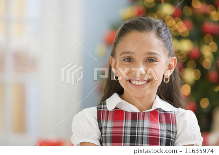 Hispanic girl in front of Christmas tree Hispanic girl in front of Christmas tree 11635974