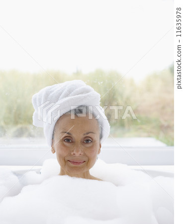 Portrait of elderly woman in bubble bath with towel wrapped around head Portrait of elderly woman in bubble bath with towel wrapped around head 11635978