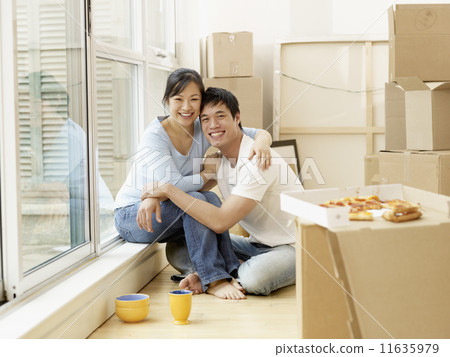 Asian couple surrounded by moving boxes 11635979