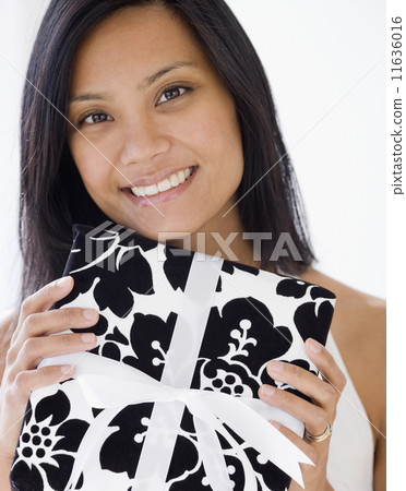 Pacific Islander woman holding gift Pacific Islander woman holding gift 11636016