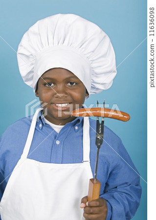 African boy in chef's hat holding hot dog 11636098