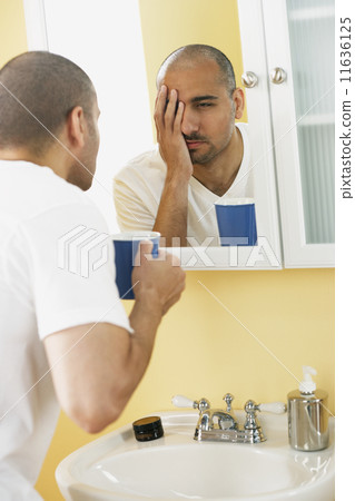 Middle Eastern man looking in mirror 11636125