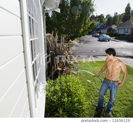 Bare-chested Hispanic man watering plants Bare-chested Hispanic man watering plants 11636129
