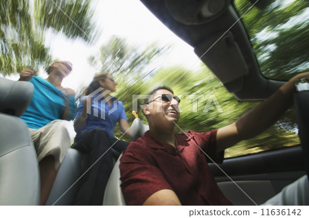 Man and women driving in convertible 11636142