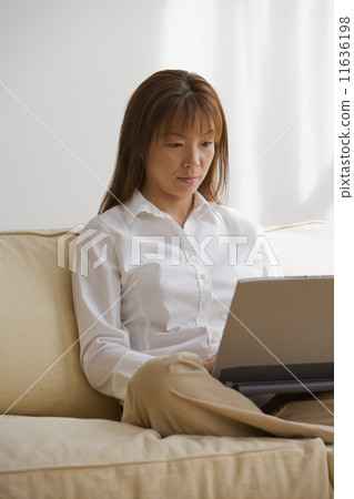 Asian woman looking at laptop Asian woman looking at laptop 11636198