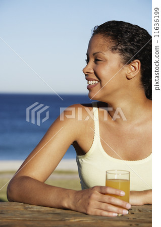 Mixed Race woman drinking juice Mixed Race woman drinking juice 11636199
