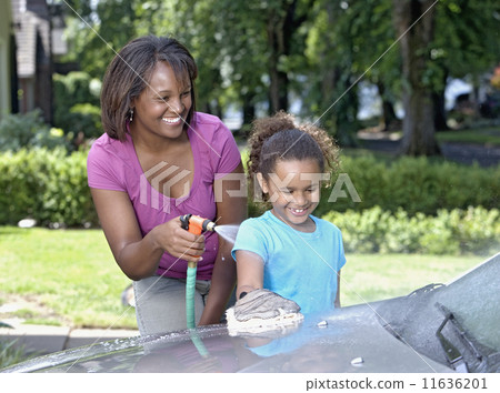 African mother and young daughter washing car African mother and young daughter washing car 11636201