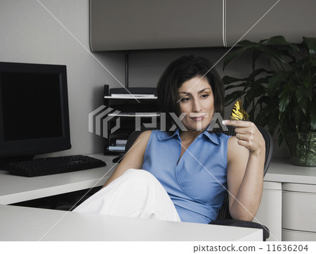 Hispanic businesswoman with butterfly on finger Hispanic businesswoman with butterfly on finger 11636204