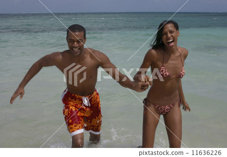 Multi-ethnic couple running in water 11636226