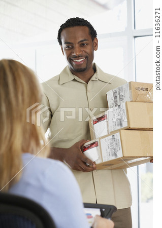 Woman signing for packages from African deliveryman 11636271