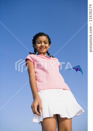 Low angle view of Hispanic girl with kite in background 11636274