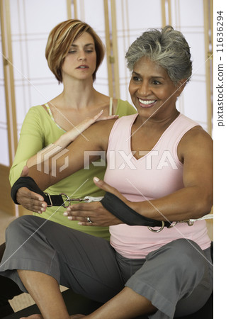 African woman exercising with personal trainer 11636294