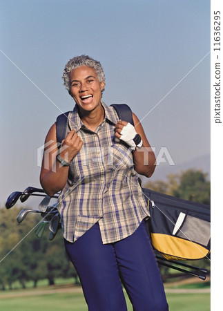 Senior African American woman carrying golf bag Senior African American woman carrying golf bag 11636295