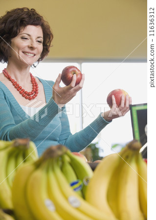 Woman choosing apples at grocery store 11636312