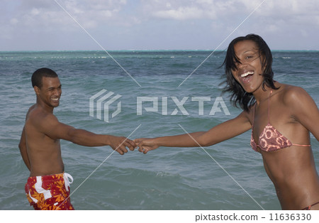 Multi-ethnic couple holding hands in water 11636330