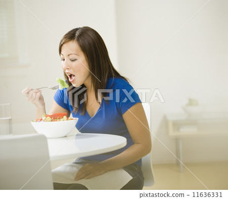 Asian woman eating salad 11636331