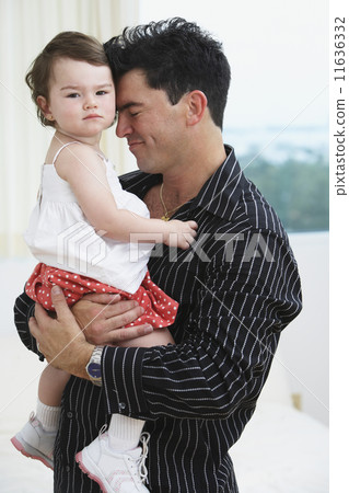 Hispanic father hugging young daughter 11636332