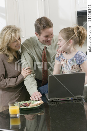 Family and laptop in kitchen  11636341