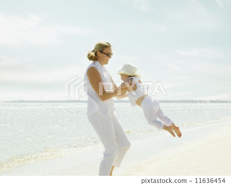 Mother playing with her daughter on the beach 11636454