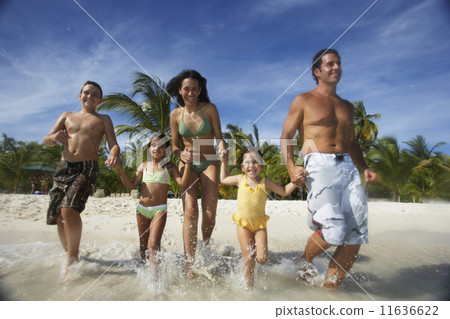 Hispanic family running into water 11636622