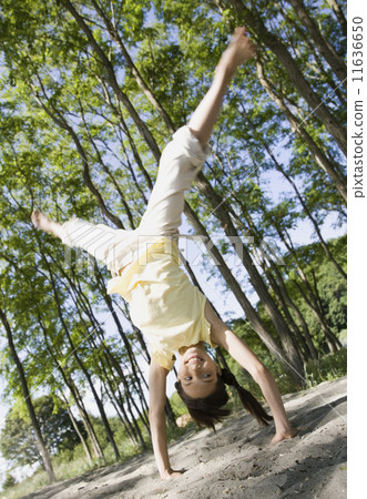 Mixed Race girl doing cartwheel Mixed Race girl doing cartwheel 11636650