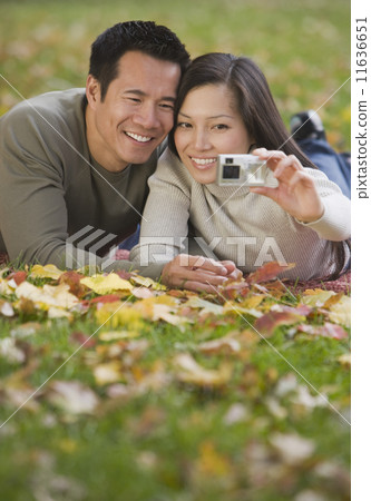 Asian couple taking own photograph Asian couple taking own photograph 11636651