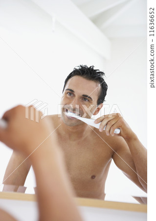 Man with bare chest brushing teeth Man with bare chest brushing teeth 11636652