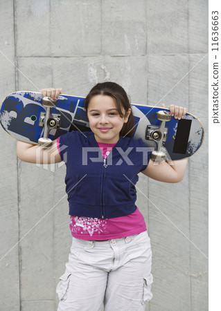 Mixed Race girl holding skateboard Mixed Race girl holding skateboard 11636663
