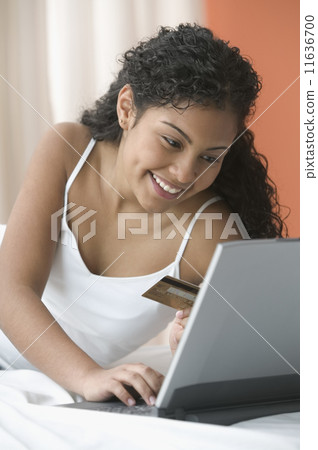 Teenage girl using credit card for online purchase 11636700