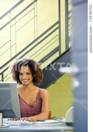 African businesswoman typing on computer 11636702